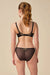 Rear view of model in Gossard Viva Sheer Embroidered Panties and bra set, showing sheer black fabric and gold lace accents for a luxurious look.