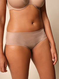 Beige bra and panties set on a neutral background