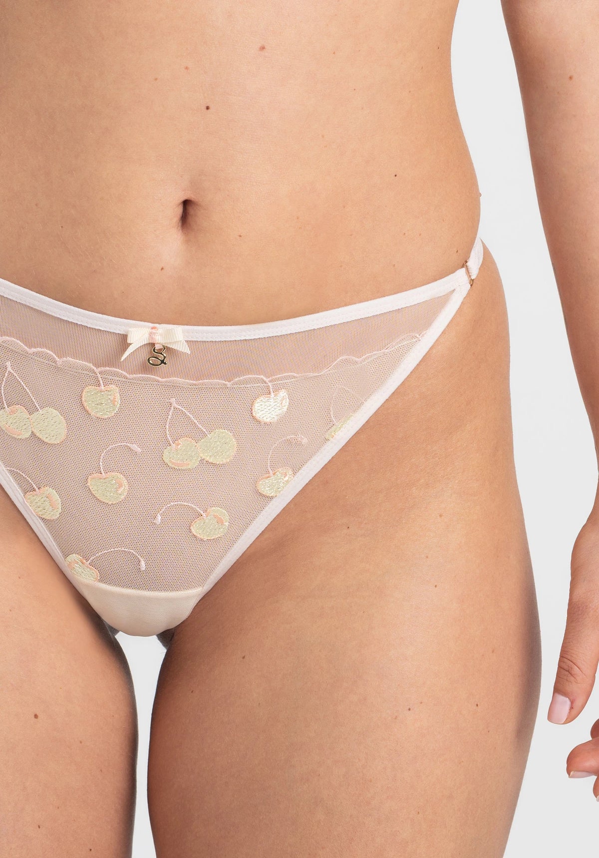 Cream sheer string thong panty with pastel cherry embroidery, low-rise cut, delicate bow detail, made of lightweight mesh fabric