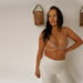 Model in Kinga Nude Demi Cup Bra Lou styled with white pants, presenting a casual yet elegant lingerie outfit combination.